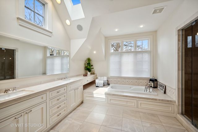a bathroom with a granite countertop double vanity sink and mirror