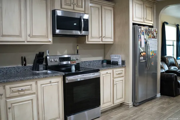 a kitchen with stainless steel appliances granite countertop a stove a microwave and cabinets