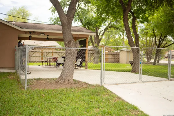 a view of a house with backyard and a tree
