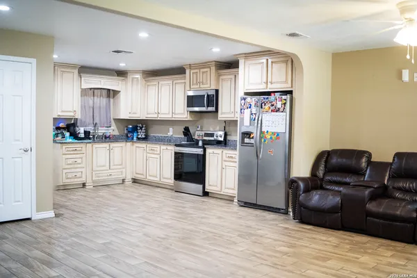 a kitchen with stainless steel appliances granite countertop a refrigerator and a stove top oven