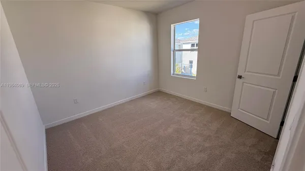 a view of an empty room with windows and closet