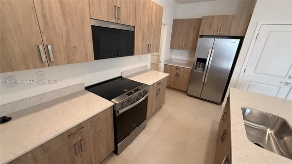 a kitchen with stainless steel appliances granite countertop a refrigerator stove and sink