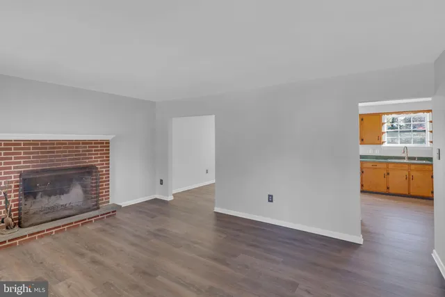 a view of an empty room with a fireplace and a window