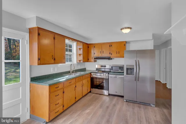 a kitchen with stainless steel appliances granite countertop a stove a sink and a refrigerator