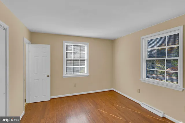 a view of empty room with wooden floor and windows