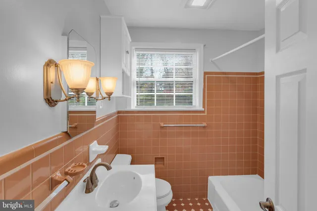 a bathroom with a sink a toilet and mirror