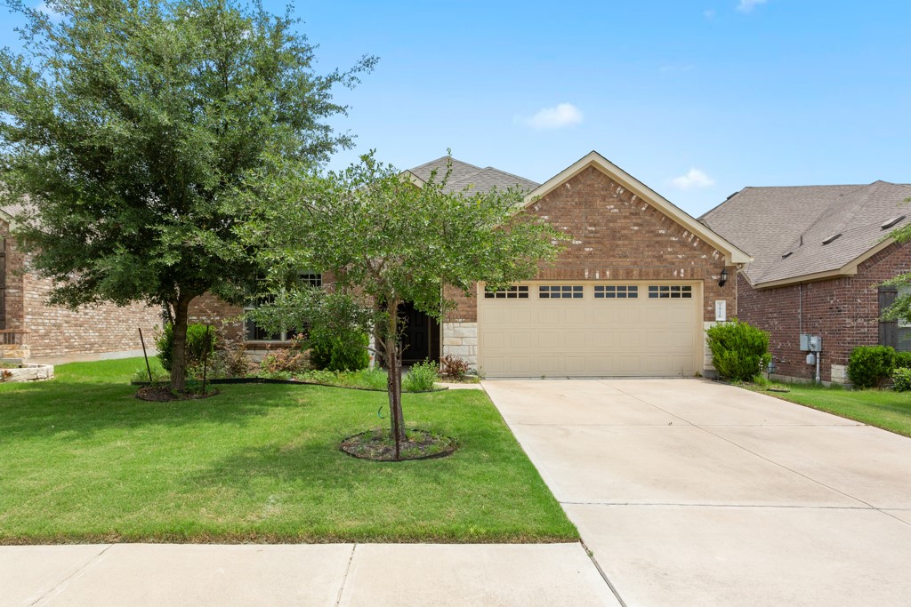 1916 Elaina Loop Leander, TX 78641 - Photo 3 of 23 a front view of a house with a garden and a tree