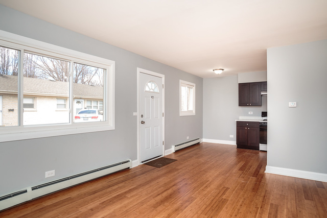 601 Highview Avenue Addison, IL 60101 - Photo 7 of 50 an empty room with wooden floor and windows
