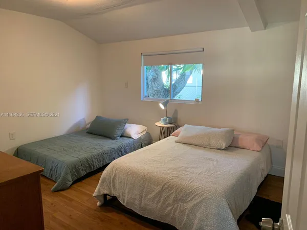 a bedroom with two beds and a lamp