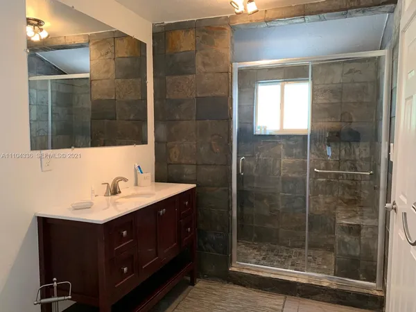 a bathroom with a shower sink and mirror