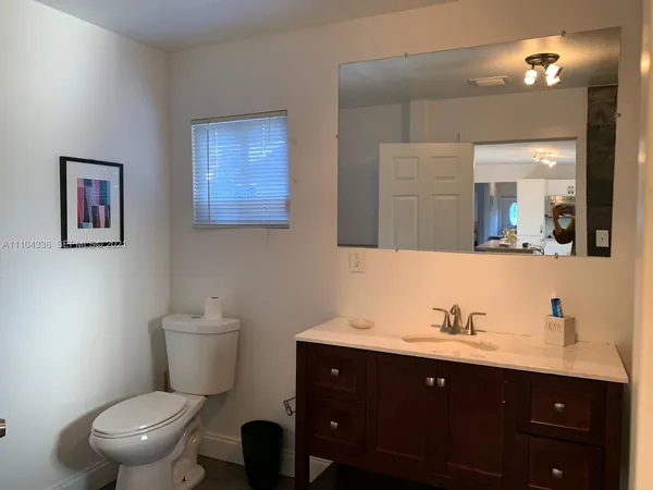 a bathroom with a toilet sink and mirror