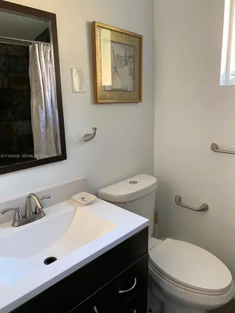 a bathroom with a sink a toilet and mirror