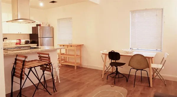 a kitchen with a table chairs refrigerator and cabinets