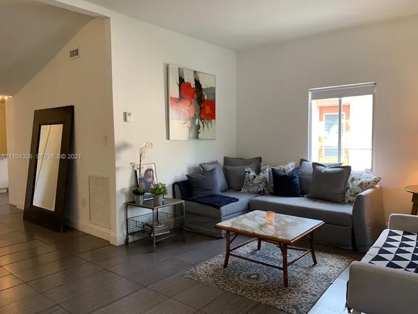 a living room with furniture a rug and a window