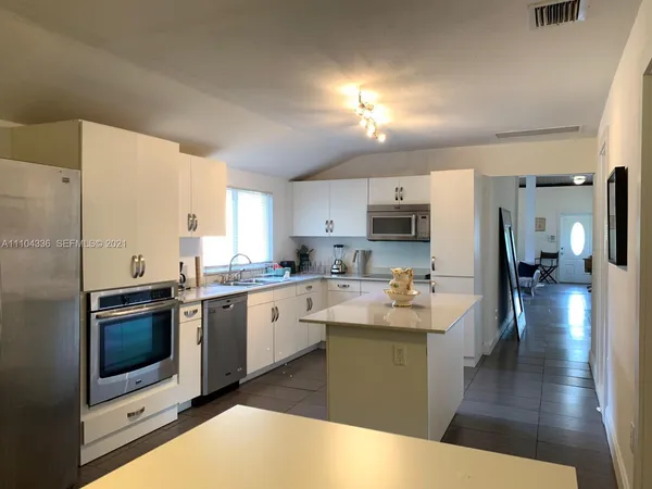 a kitchen with stainless steel appliances a sink dishwasher stove refrigerator and microwave