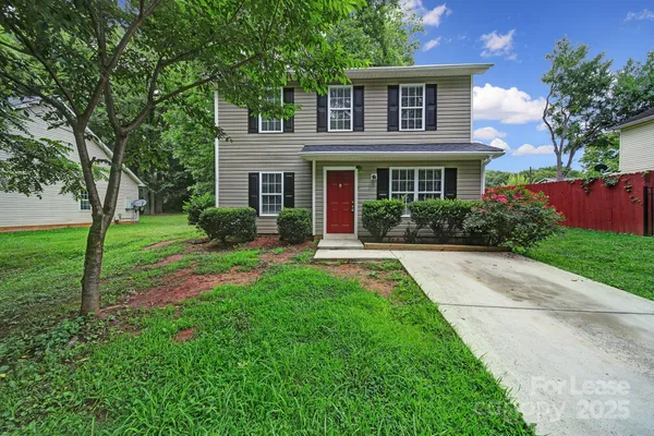 a front view of a house with yard and green space