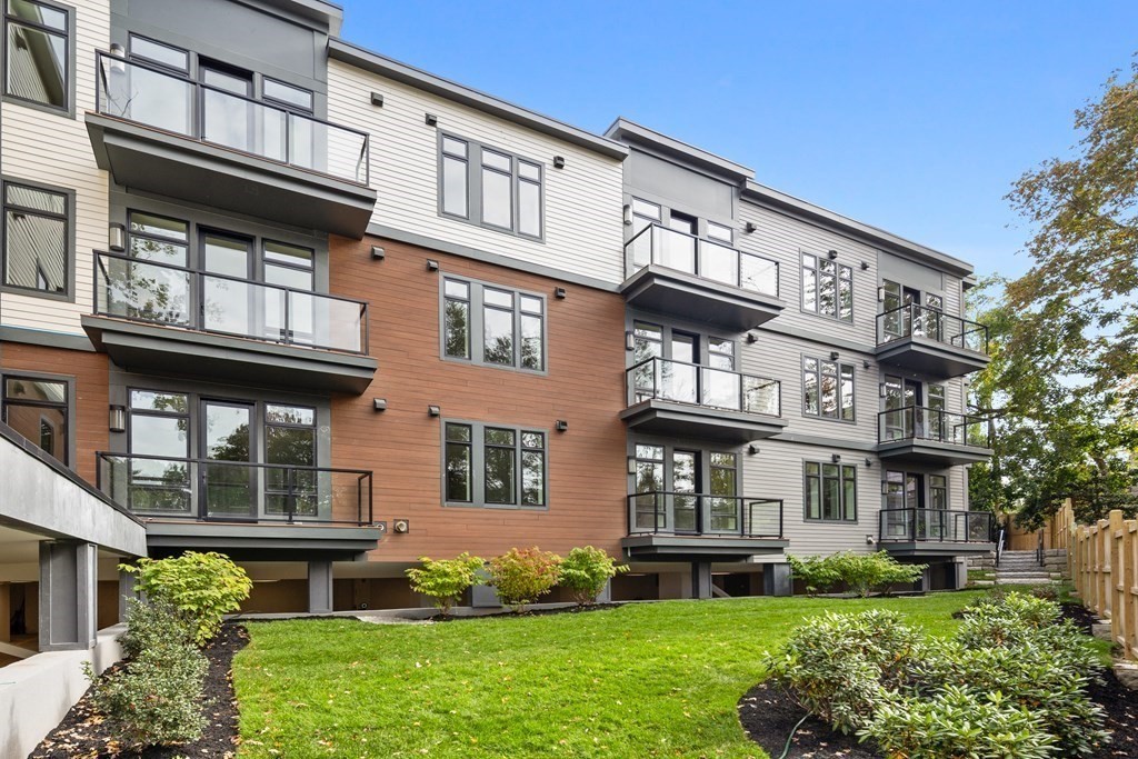 20 Kinmonth Road, Unit 106 Newton, MA 02468 - Photo 16 of 21 a front view of a residential apartment building with a yard