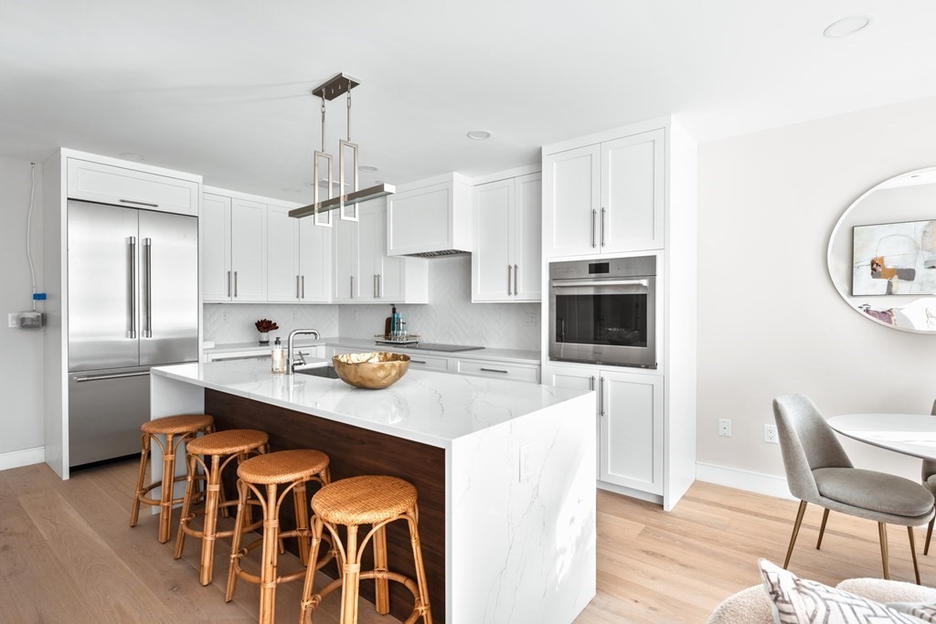 20 Kinmonth Road, Unit 106 Newton, MA 02468 - Photo 5 of 21 a kitchen with a dining table chairs and cabinets