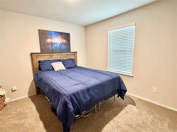 a bed sitting in a bedroom next to a window