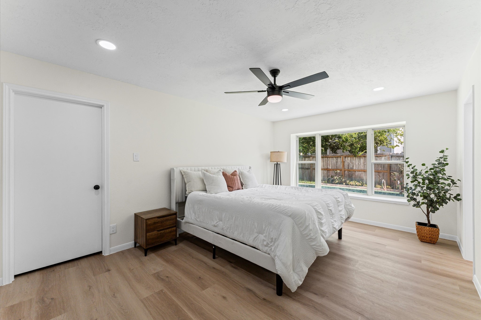 2914 Riata Lane Houston, TX 77080 - Photo 22 of 39 a spacious bedroom with a bed a chandelier and a large window