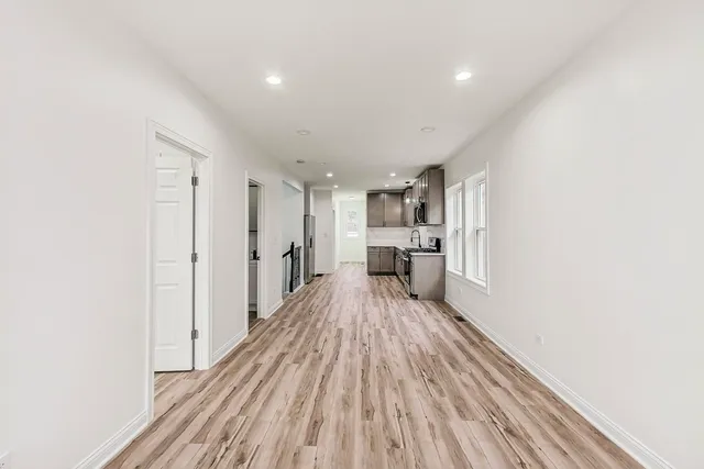 a kitchen with granite countertop a sink stove refrigerator and cabinets