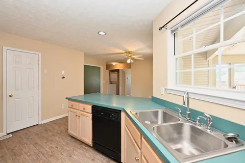a kitchen with a sink and a stove next to a large window