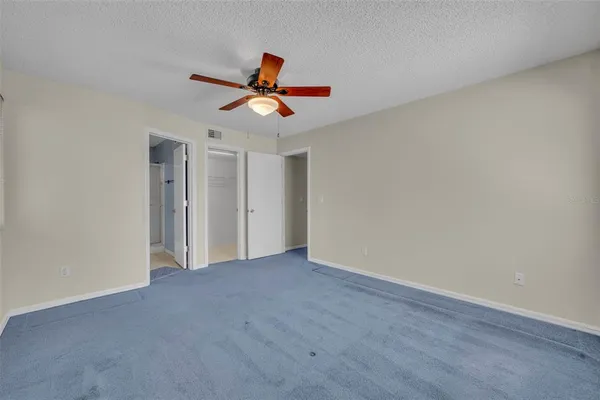 a view of a room with wooden floor and ceiling fan