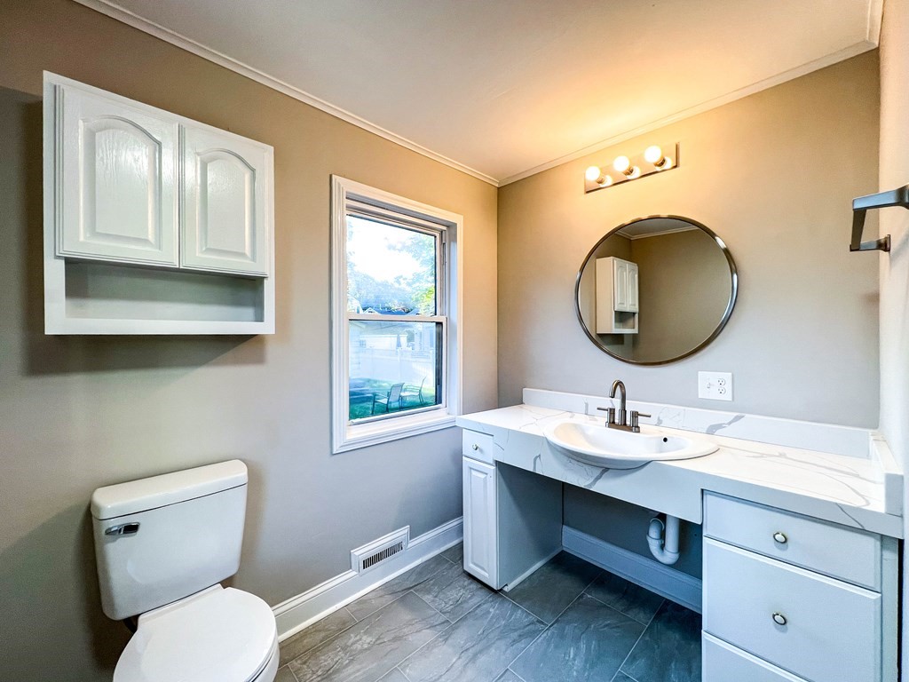 67 Waltham Street Maynard, MA 01754 - Photo 11 of 29 a bathroom with a toilet a sink and mirror