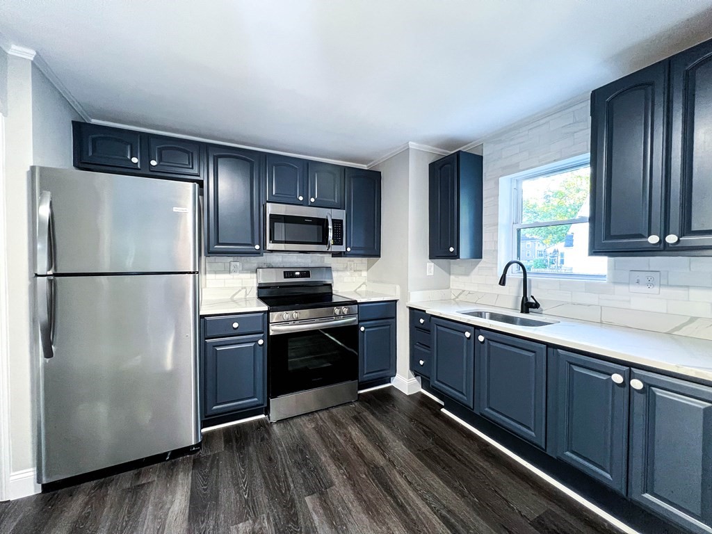 67 Waltham Street Maynard, MA 01754 - Photo 7 of 29 a kitchen with stainless steel appliances granite countertop a refrigerator stove top oven and sink
