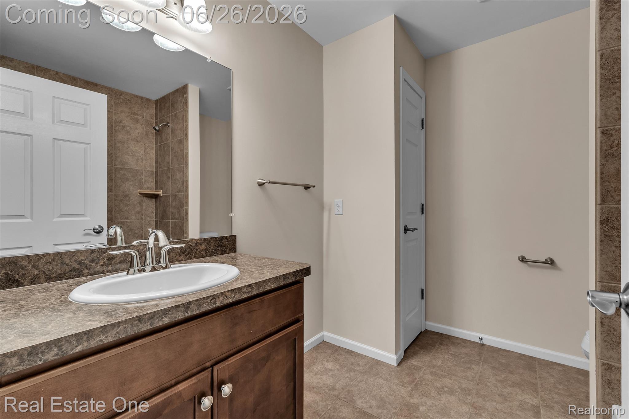 41590 Mitchell Road Novi, MI 48377 - Photo 27 of 45 Bathroom featuring a wood-finish vanity with a built-in sink, a stone-look countertop, a large wall mirror, and overhead vanity lighting