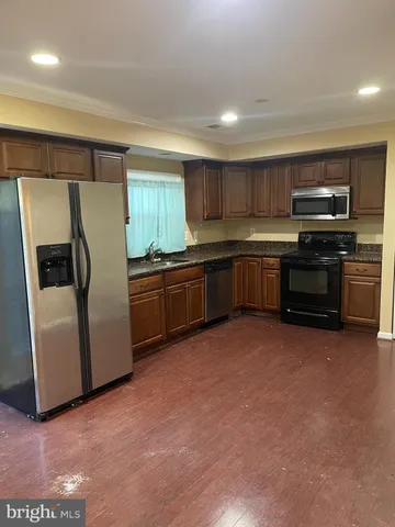 a kitchen with stainless steel appliances granite countertop a refrigerator and a stove top oven
