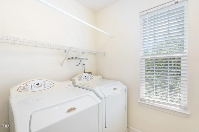 an empty room with a fan & a window