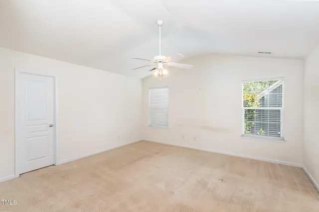 an empty room with a window and a ceiling fan