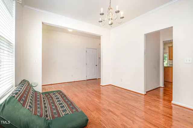 a view of a bedroom with wooden floor and a ceiling fan