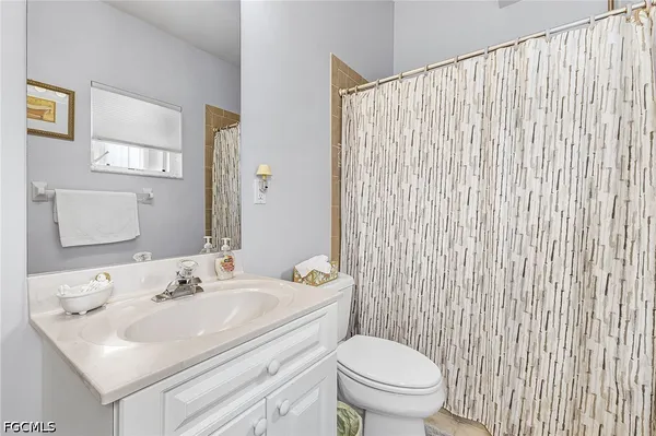 a bathroom with a sink a toilet and shower curtain