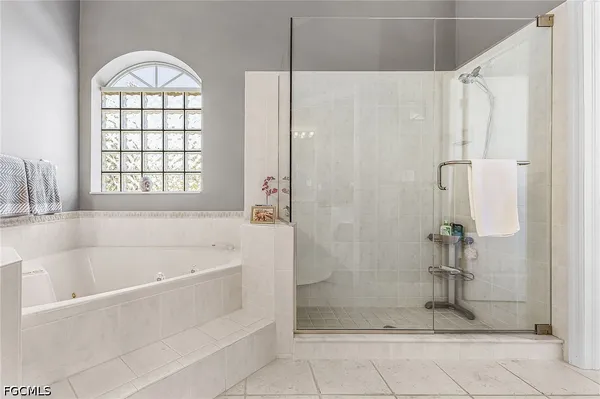 a bathroom with a bathtub a shower and a window