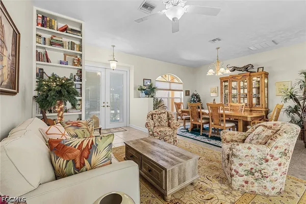 a living room with furniture a chandelier and a flat screen tv