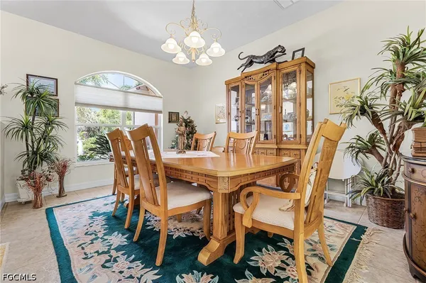 a view of a dining room with furniture a chandelier and wooden floor