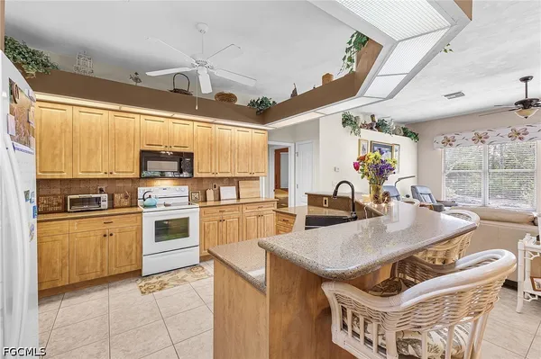 a kitchen with stainless steel appliances kitchen island granite countertop a table chairs in it and wooden floors