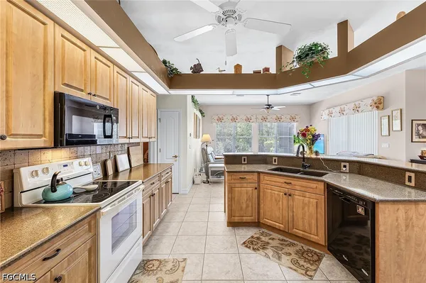 a kitchen with stainless steel appliances granite countertop a sink a stove oven a counter top space and cabinets