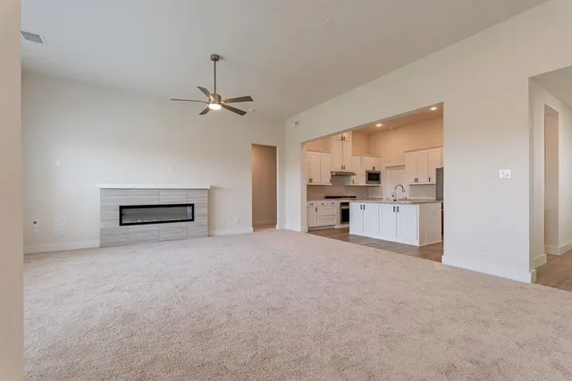 a view of empty room with window and ceiling fan