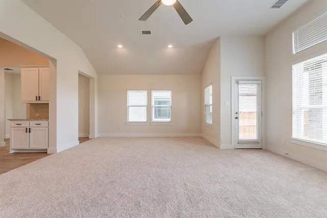 a view of an empty room with a fireplace and a window