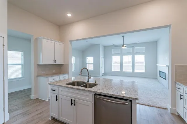 a kitchen with kitchen island granite countertop a sink and refrigerator