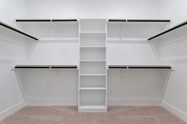 a view of walk in closet with empty racks
