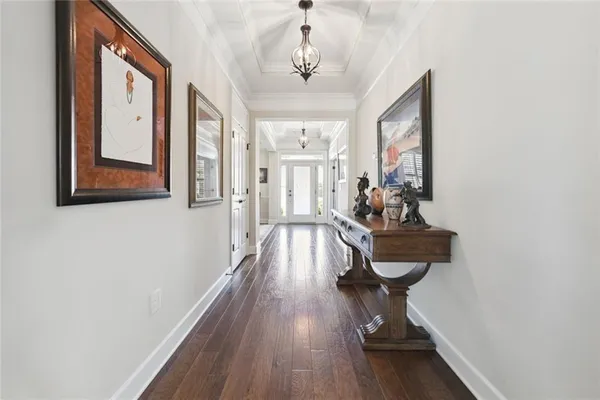 a kitchen with stainless steel appliances white cabinets a sink dishwasher a stove and a dining table with wooden floor
