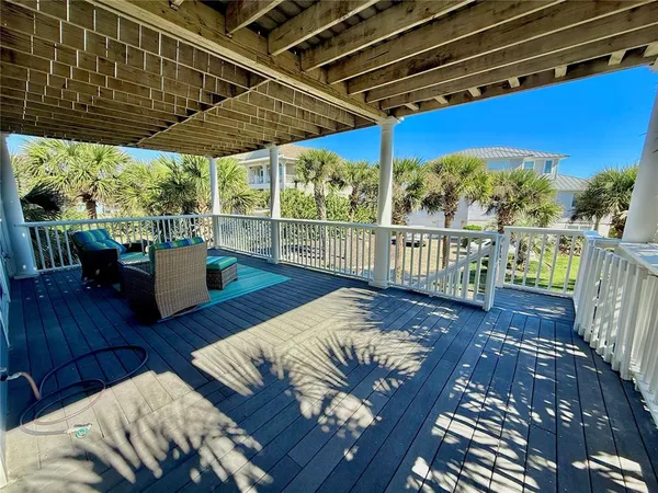 a view of a balcony with wooden floor and seating space