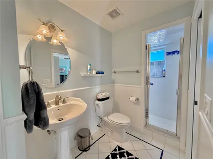 a bathroom with a sink a toilet and shower