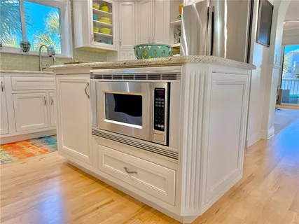 a kitchen with granite countertop stainless steel appliances stove top oven and cabinets