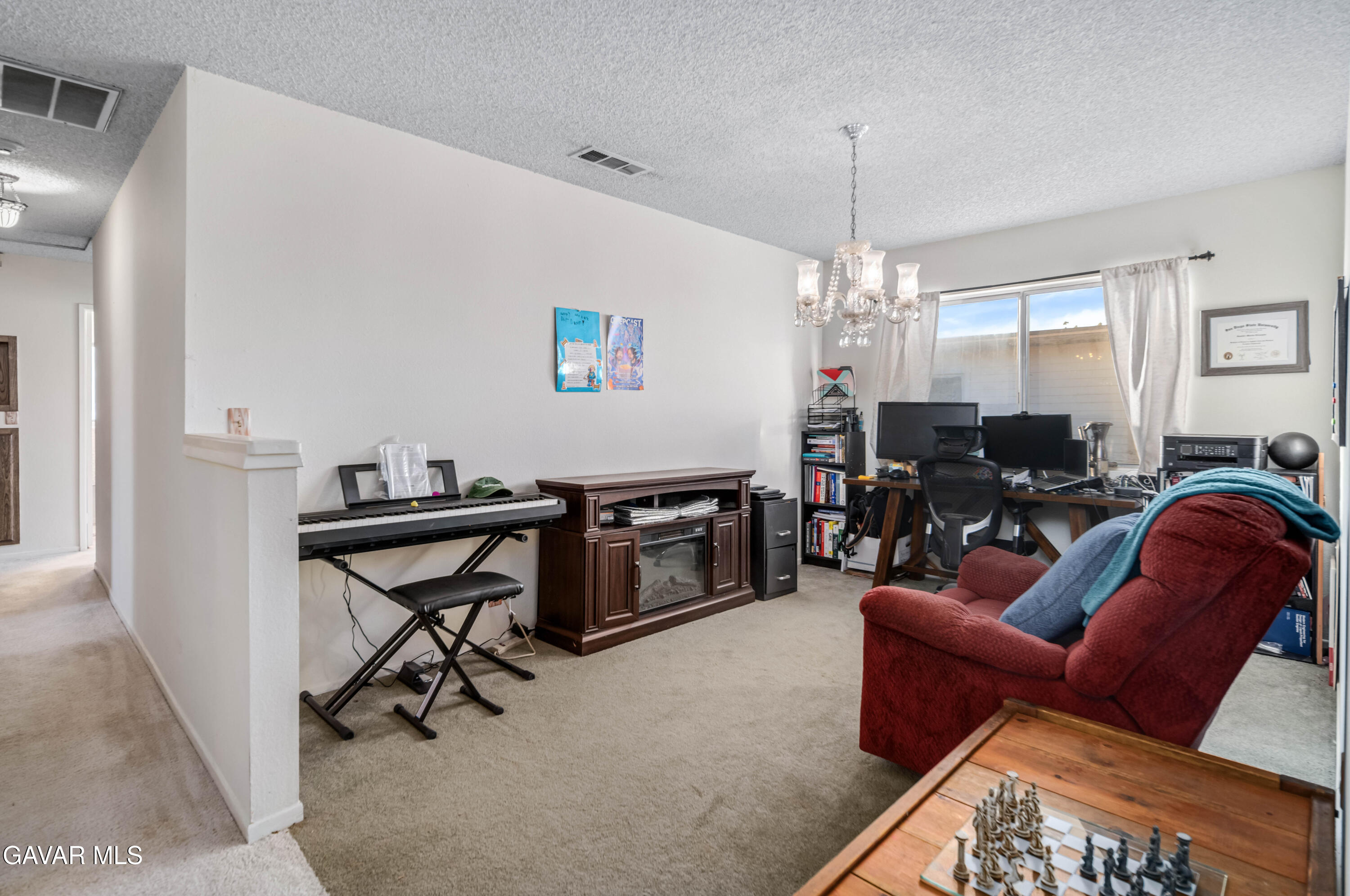 20539 East Ave R Palmdale, CA 93591 - Photo 18 of 55 a living room with furniture a window and a chandelier