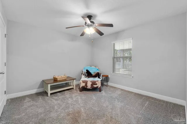 a bedroom with bed and a chandelier fan